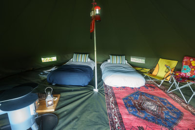 Cozy and stylish interior of a bell tent, perfect for a tranquil glamping retreat.